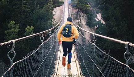 person walking away on a bridge